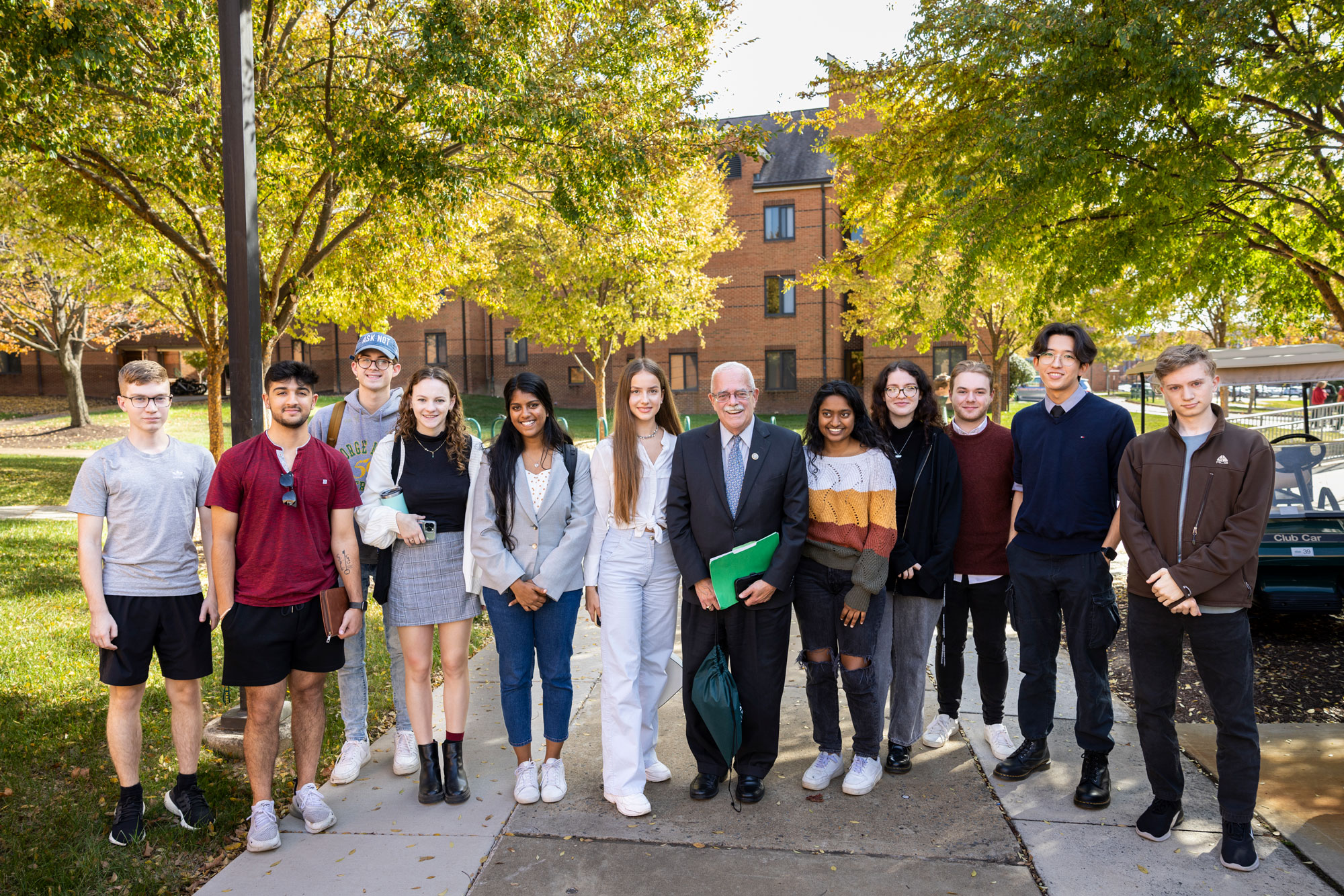 A group of students stands outside on the Fairfax Campus with Gerry Connolly.